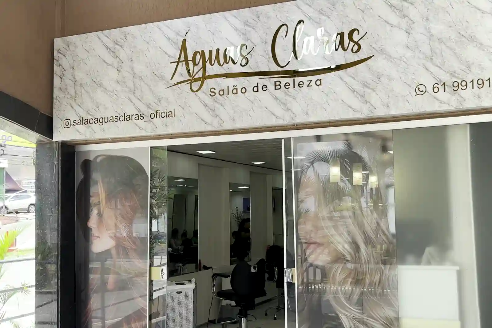 Fachada do Salão Águas Claras: letreiro em mármore claro com o nome em dourado e a porta de vidro do salão
